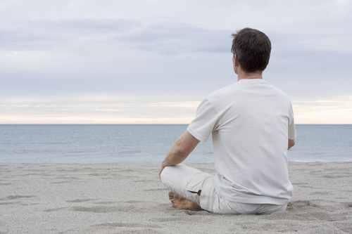 Man meditating on beach